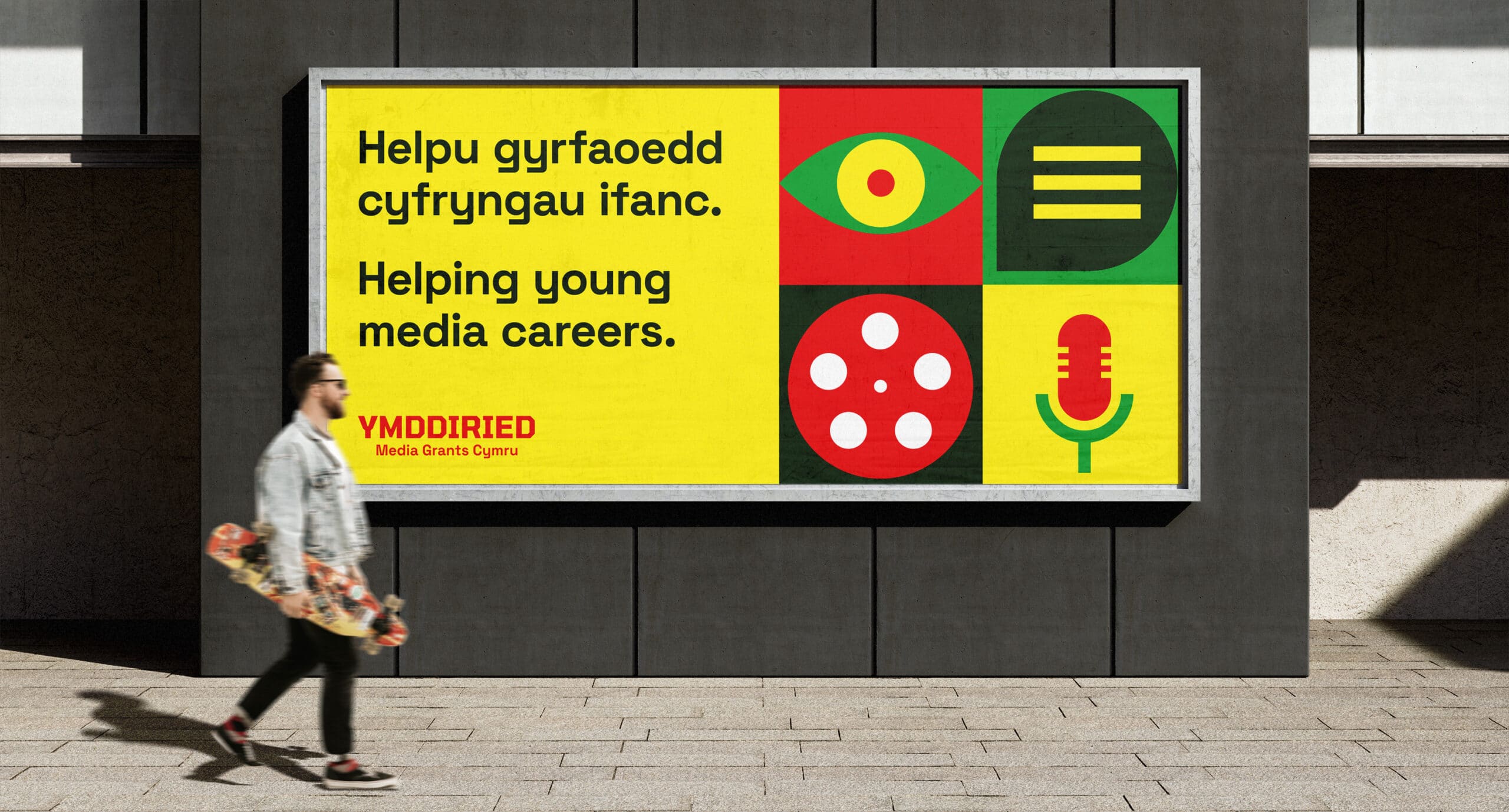 Ymddiried branded billboard with man walking past in front of it.