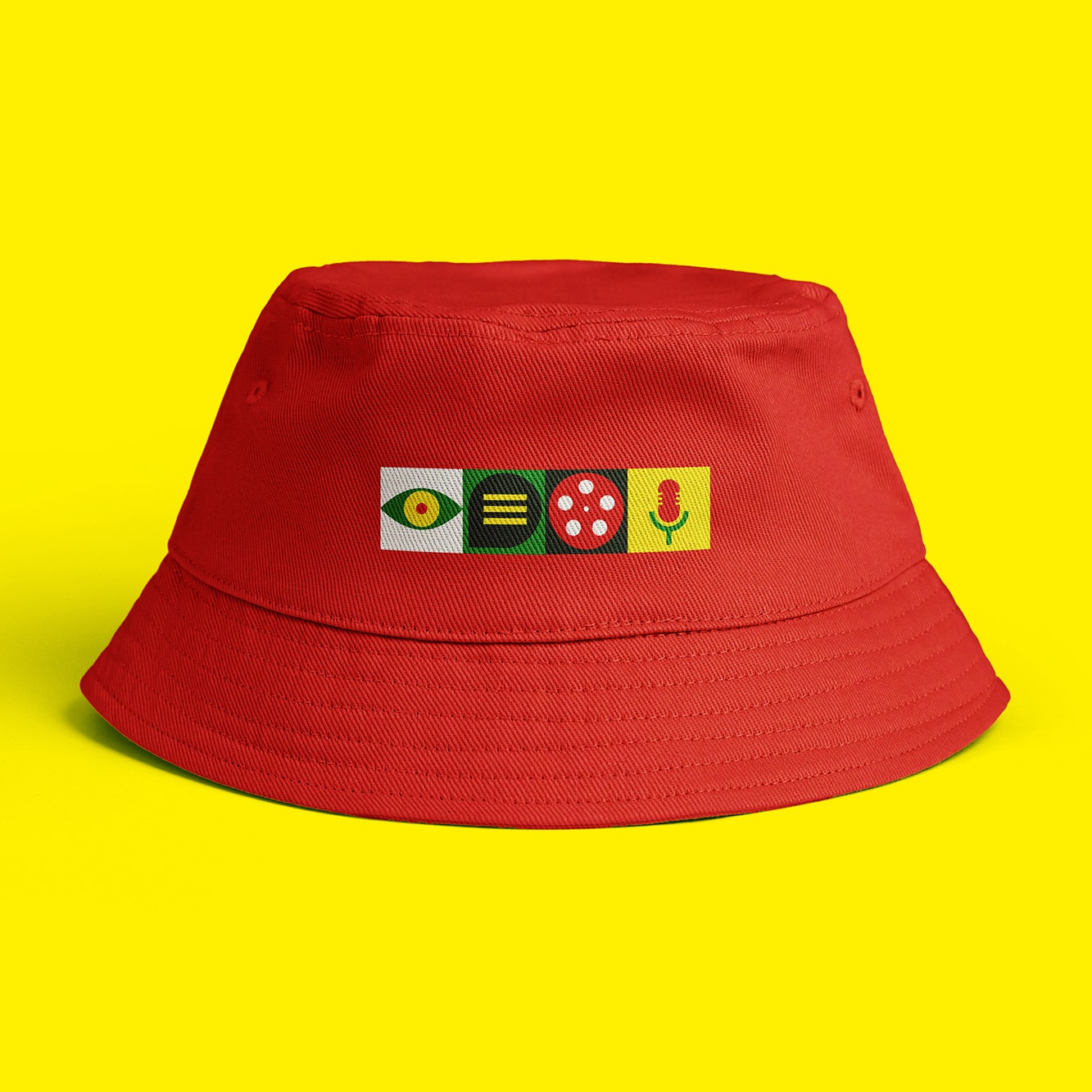 Red bucket-hat featuring Ymddiried block-logo on the front in contrasting colours.