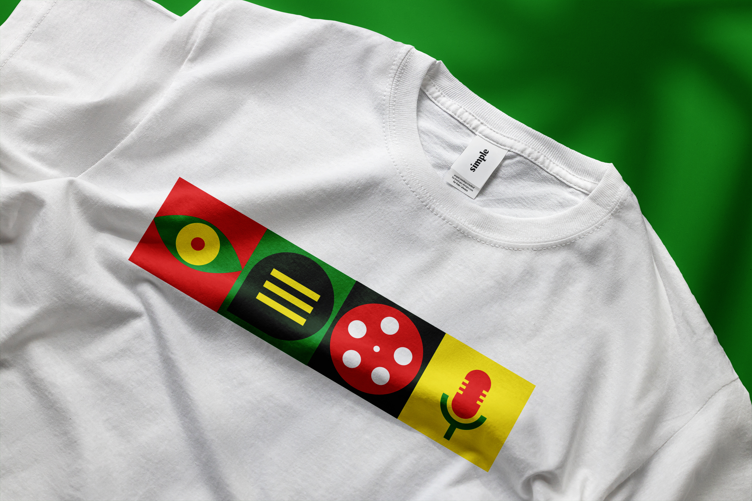 White t-shirt featuring the Ymddiried logomark of 4 blocks of icons in yellow, red, light and dark green.