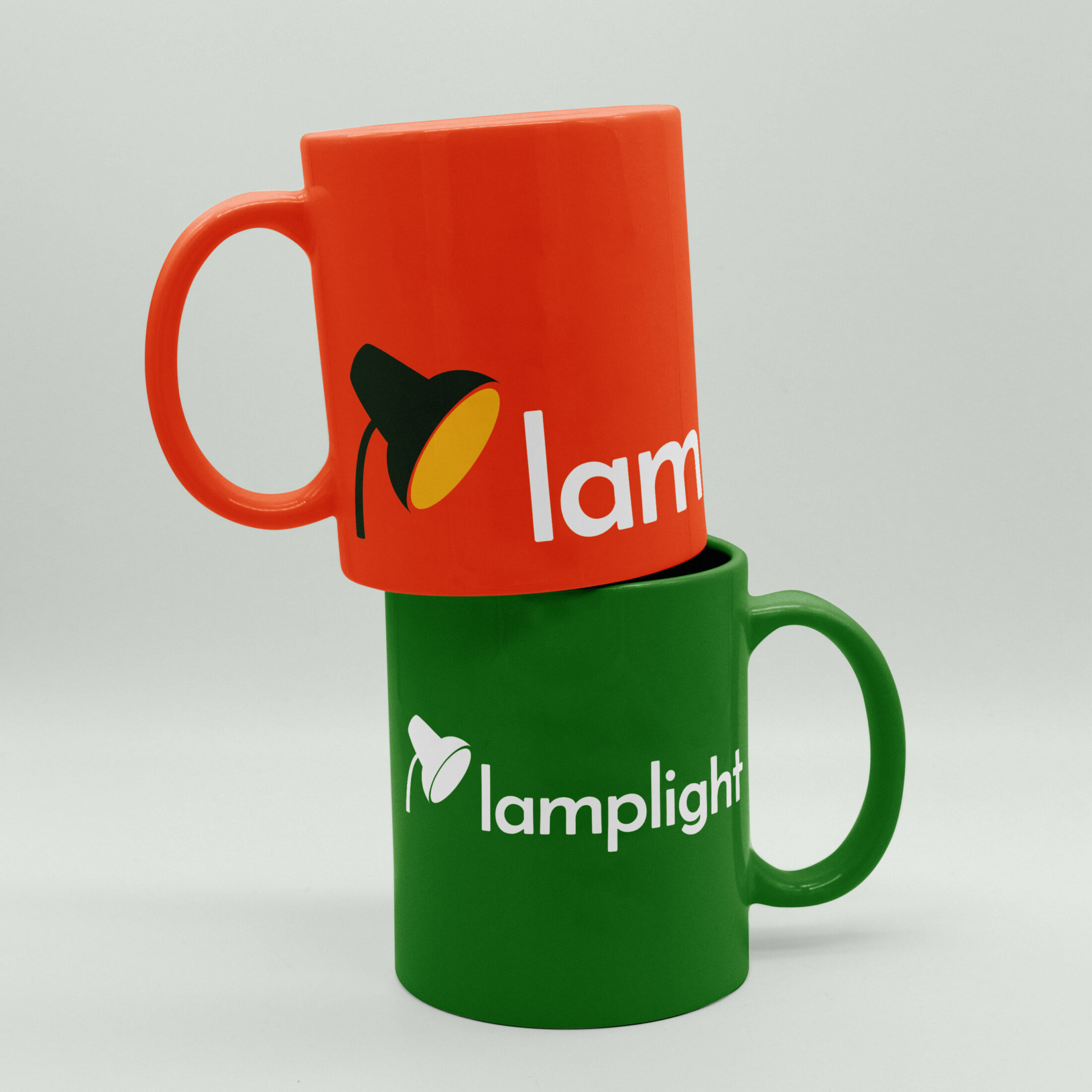 Lamplight branded mugs featuring the organisation’s accessible visual identity, photographed on a clean surface