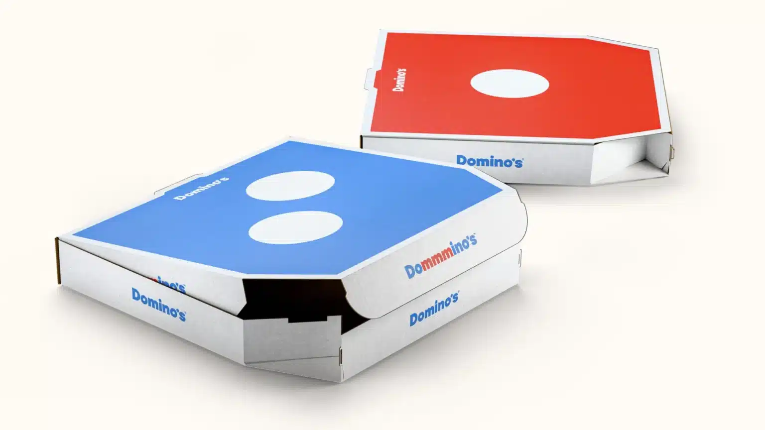 Domino’s refreshed pizza boxes: blue and red lids with bold pips and updated Domino’s wordmark.