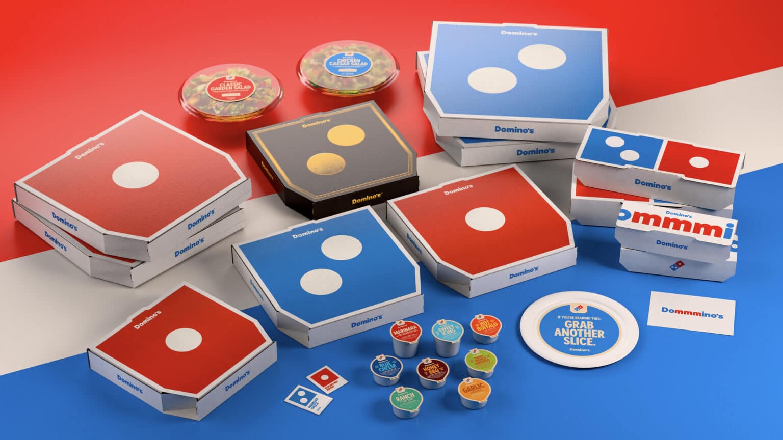 Domino’s packaging line-up after the refresh, with mixed box sizes and dipping sauces on brand colours.