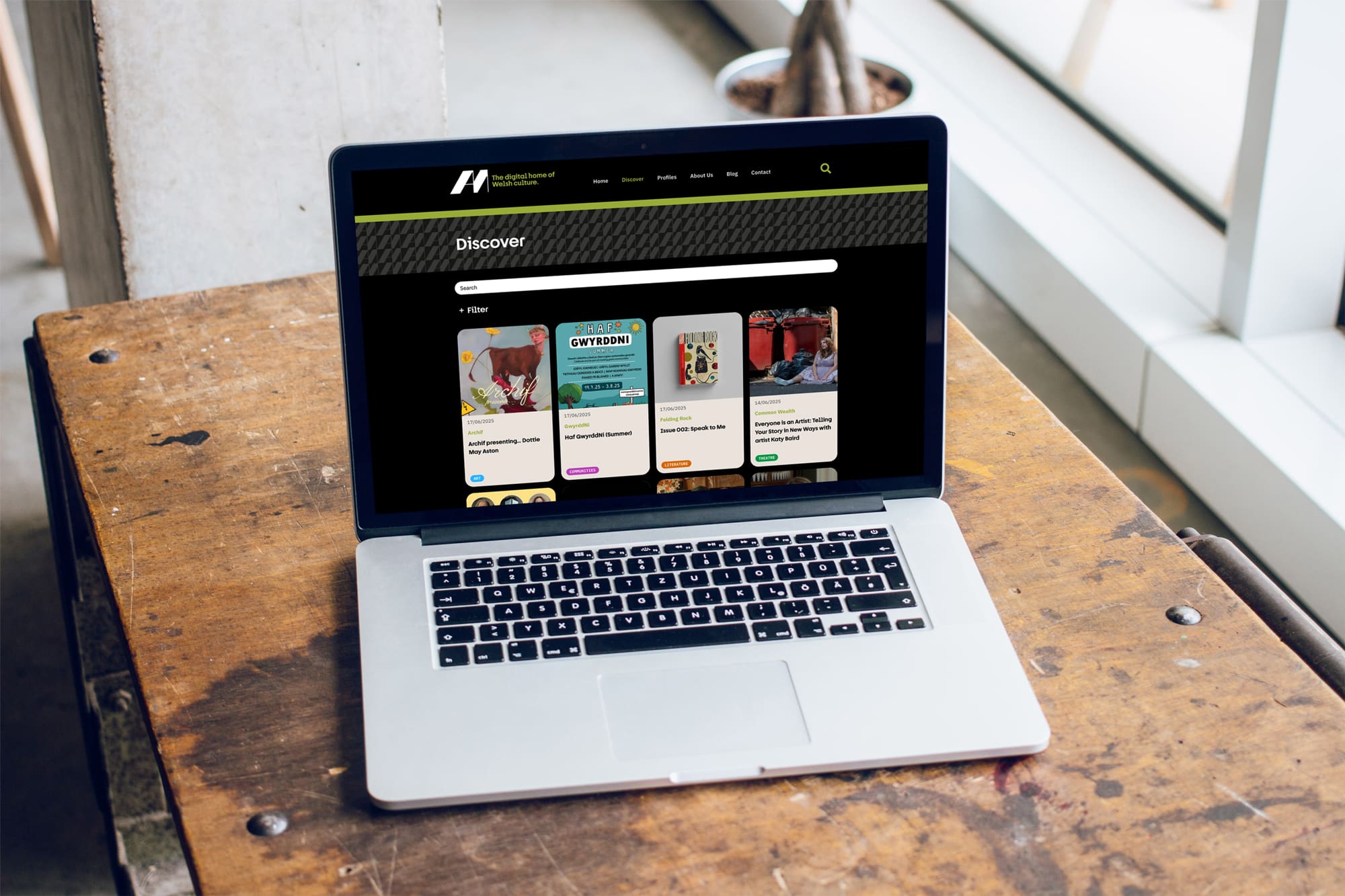 Laptop showing the Am bilingual WordPress website Discover page, designed by Design Tribe in Cardiff; web design and WordPress development in Wales.