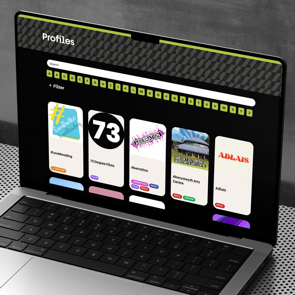 Profiles directory on the Am bilingual WordPress website with A–Z browse and theme filters; responsive web design and development by Design Tribe, Wales.