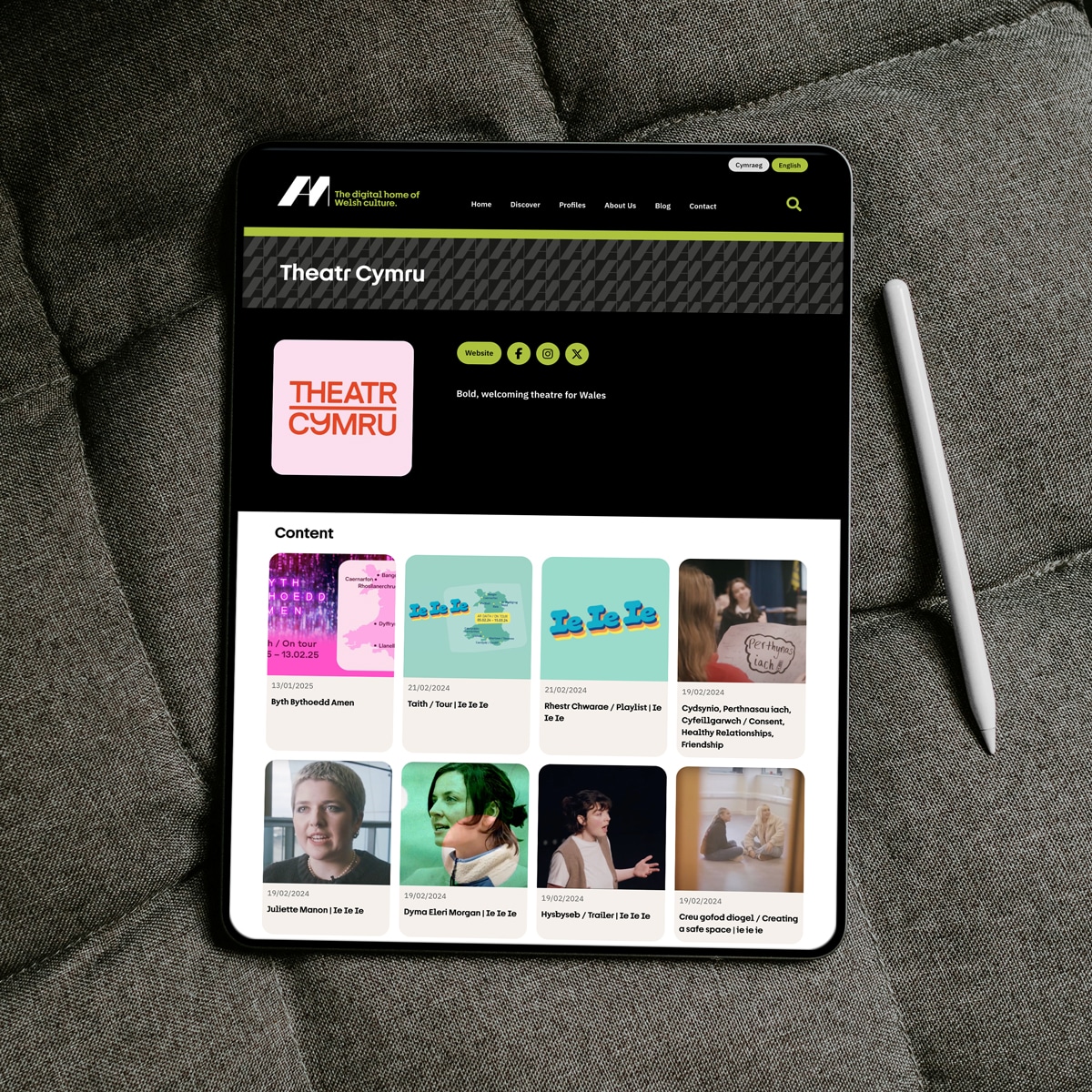 iPad showing the Am bilingual WordPress website, organisation profile with content grid; web design and development by Design Tribe, Wales.